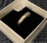 Sterling silver ring displayed in a white box with a black velvet interior, showing the floral engravings on the outer band and a tag reading 'sterling 925'