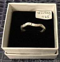 Sterling silver contoured ring in white box with label 'sterling 925'