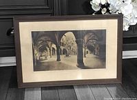 Framed vintage black and white print featuring arched architectural columns and vaulted ceilings.