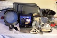 4 rectangular cookie sheets, Oneida springform pans, Bundt pan, hand mixer, measuring tools, ceramic pitcher, baking rack, and accessories on display