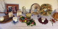 Wide view showing dried flower wreaths, plastic flower candle wreaths, various candles, Dutch painted door chime, and decorative art and pottery.