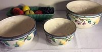 Three Mikasa nesting ceramic bowls with grape and fruit motif, varying sizes, glazed finish