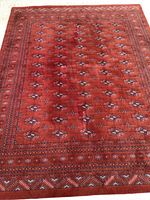Full view of red wool area rug showing overall medallion pattern and border