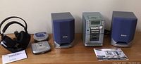 Full view of the Philips portable sound system including central unit, speakers, headphones on stand, CD stand, and manuals.