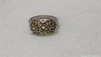 Front view of vintage ladies ring with floral rhinestone design on silver-tone band
