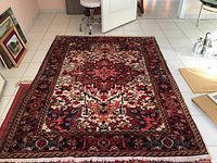 Entire rug laid flat on tiled floor showing full medallion design and border