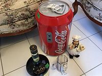 Coca-Cola mini fridge sized about 11x18 inches, chef figurine, green bottle-shaped ice bucket, humorous mug on floor
