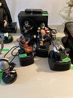 Group shot of five figurine speakers with power box and remote