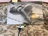 Black and white Marilyn Monroe photo print on floral fabric couch, showing full print and cufflinks box on front