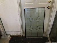 Full view of stained glass panel leaning against a door, showing the entire 22x36 insert with diamond pattern.