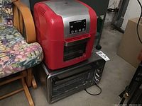 Full view of the red Todd English Multi Air Fryer sitting on top of the stainless steel toaster oven showing both appliances and their general condition.