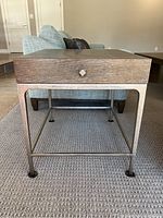 Side view of Bernhardt side table showing drawer front and iron base with hammered texture.