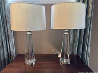 Pair of decorative table lamps with white drum shades on a wooden table