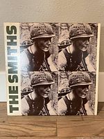 The Smiths album cover with 'Meat is Murder' helmet image repeated four times and the band name 'THE SMITHS' on the left vertical side.