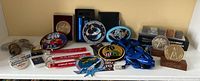 Overview of various patches, pins, keychains, and medallions laid out for display to showcase lot contents