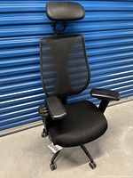 Three-quarter front-left view showing overall chair structure including seat, backrest, armrests, headrest, and base