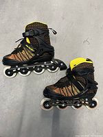 Side view of the pair of men's size 7.5 Papaison inline rollerblades showing the multicoloured fabric upper and black frame and wheels.