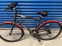 Side view of the bike showing frame, wheels, mudguards, seat and handlebar.