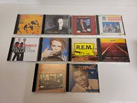 Top view of 10 assorted music CDs showing front cover art including Eurythmics, Marc Cohn, R.E.M., and others.