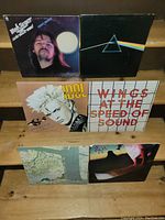 Photo showing the front covers of six classic rock vinyl albums including Bob Seger, Pink Floyd, Billy Idol, Wings, and two others with scenic and silhouette art.