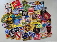 Top view of assorted patches and badges spread out displaying vibrant colors and varied shapes.