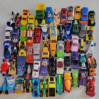 Overview of the lot showing all 60 toy cars arranged in rows with various colors and designs