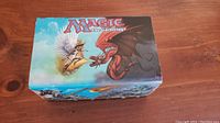 Closed box showing Magic The Gathering artwork featuring a dragon and winged figure.