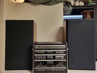 Front view of Sears stereo system flanked by two Acoustic 520 speakers.