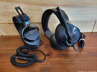 Sony DR-53 and Nubwo gaming headphones side by side on wooden surface, showing cable and design