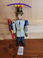 Front view of the Inspector Gadget figure with helicopter propeller hat and held red gadget tool, standing upright.