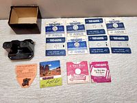 Overview of the black plastic 1940s Sawyer's Viewmaster stereoscope viewer with original box; multiple reels with U.S. states wildflowers, landmarks, and Biblical themed reels; instruction pamphlet and reel list included.