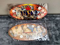 Two collectible Canadian Millennial quarter coin sets from 1990 and 1992 in original plastic packaging laid on a surface.