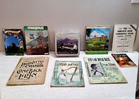 Overall view of all lot items including music sheets, travel books, biscuit tin and calendar