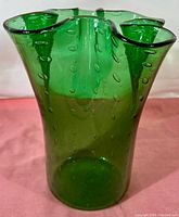 Front angle view of the emerald green handkerchief vase showing its controlled bubble pattern and ruffled top edge.
