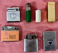 Overall image of six vintage lighters on a pink cloth background.