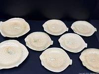 Eight cream-color fish-shaped ceramic plates from above showing 2 size variations