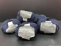 Photo showing six balls of navy blue mohair blend yarn with labels indicating Filatura di Crosa Sympathie line