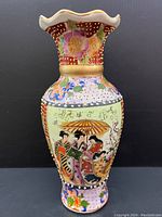 Front view of the vase showing the group of figures and floral patterns with gold moriage.