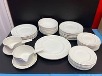 Full set of Johnson Bros Athena white china dinnerware with textured ribbing edges. Includes stacked plates, bowls, and two gravy boats with saucers.