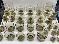 Lot arranged displaying all 37 glasses in the smoked tawny brown color, grouped by type, showing variation in size and style