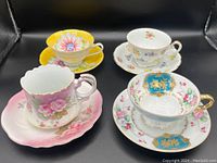 Photo of four teacup and saucer sets showing top view and partial side views, showcasing colors and patterns.