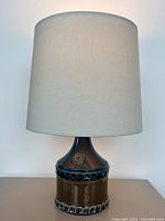 Full front view of the complete lamp showing ceramic base and intact fabric shade