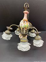 Full view of chandelier showing 5 frosted glass flower petal shades and porcelain cherub column