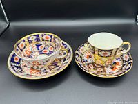 Side view showing both Birks Rawlins & Co. and Aynsley England Imari pattern teacup and saucer sets.