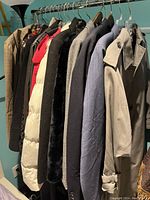 Full rack view of ten assorted women’s coats and jackets on hangers
