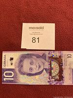 Front side of Canadian $10 dollar bill featuring a portrait of Queen Elizabeth II in purple tones.