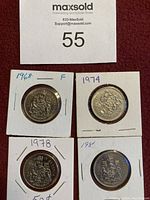 Three 50 cent coins from 1968, 1974, and 1978 displayed in white card holders with visible year markings