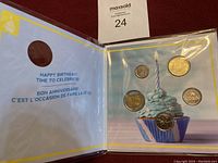 Happy Birthday coin set with five Canadian coins displayed inside a card featuring a cupcake with a lit candle and bilingual birthday greeting.