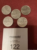 Reverse sides of five Canadian one dollar coins showing the 1982 Canadian Constitution signing scene.