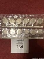 Complete set of 12 Canadian 25 cent quarters commemorating 125 years of Confederation in plastic holder.